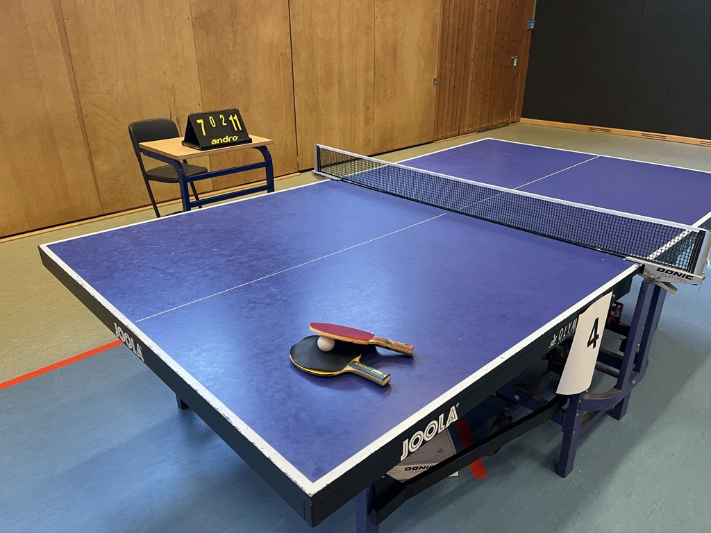 Eine Tischtennisplatte mit 2 Schlägern und einem Ball